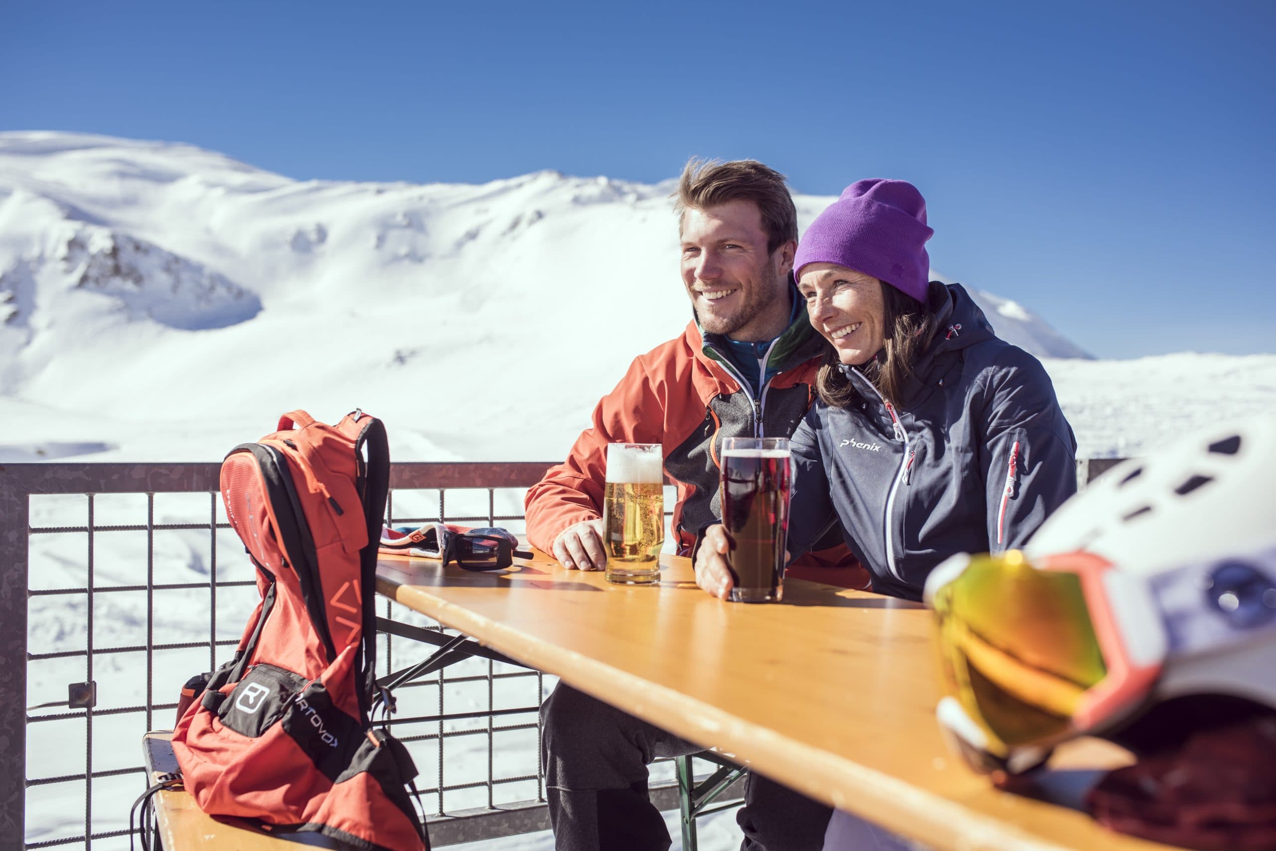 couple enjoying a drink on a terrace in the sun